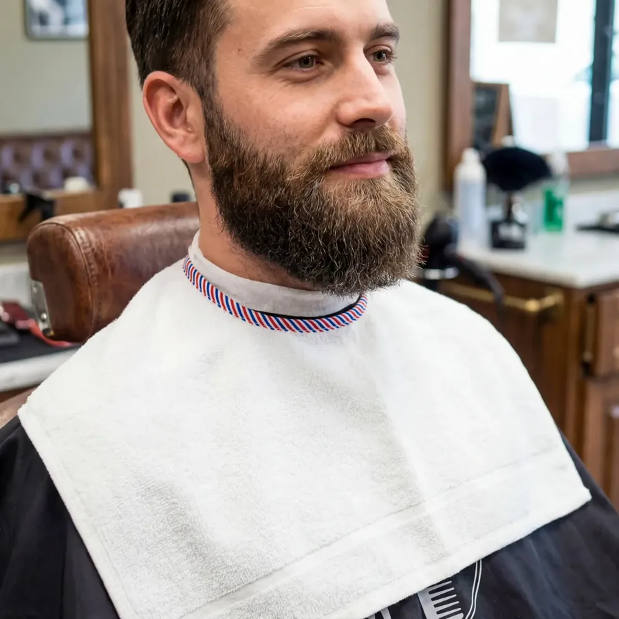 La Serviette Barber posée devant un client barbu, au salon